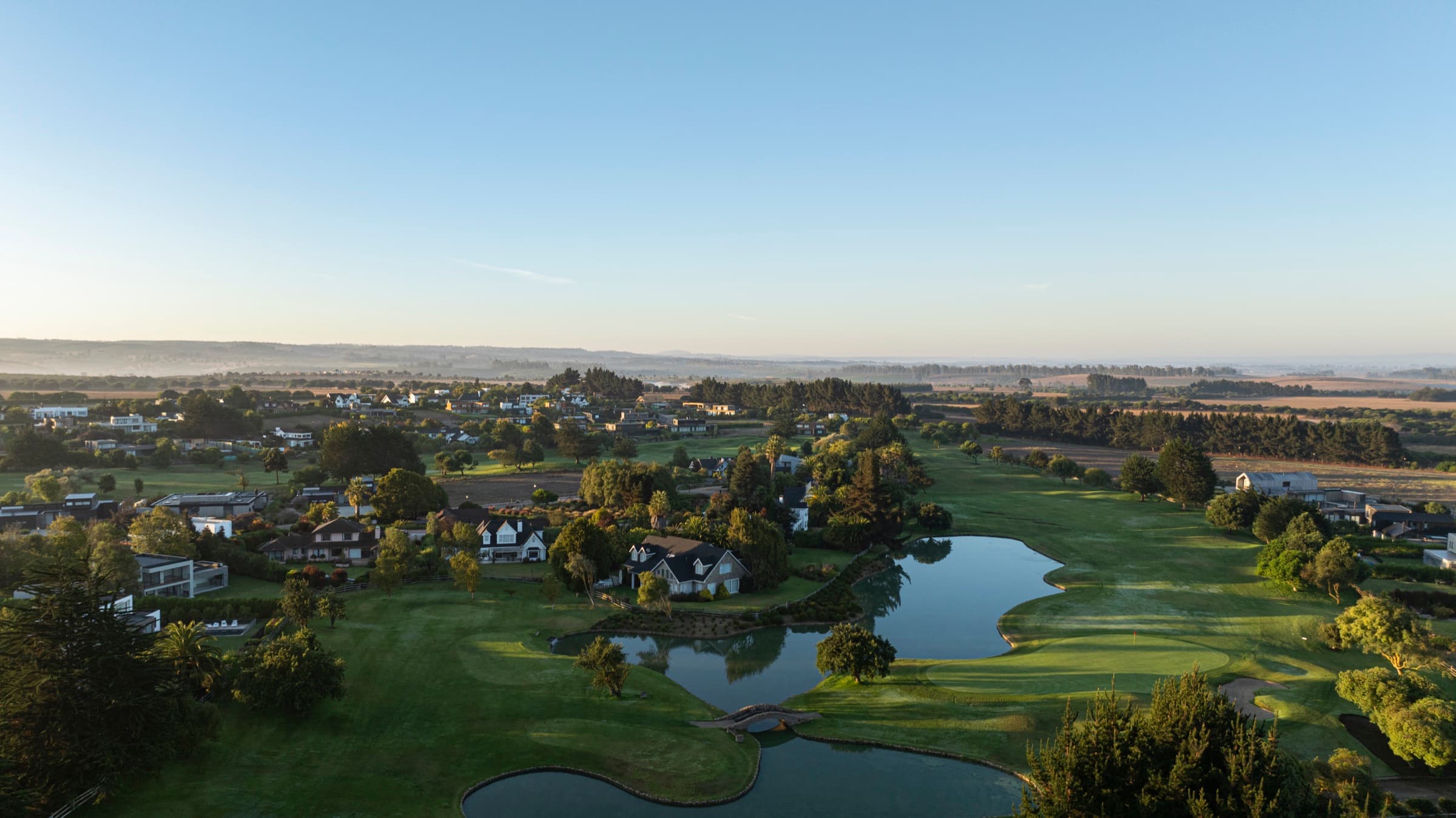 Panorámica aérea del condominio y sus lagunas al amanecer